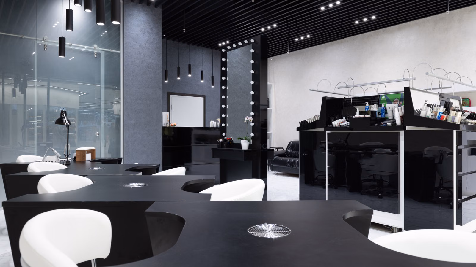 Sleek and elegant nail salon interior featuring modern black and white decor, stylish furniture, and bright lighting.